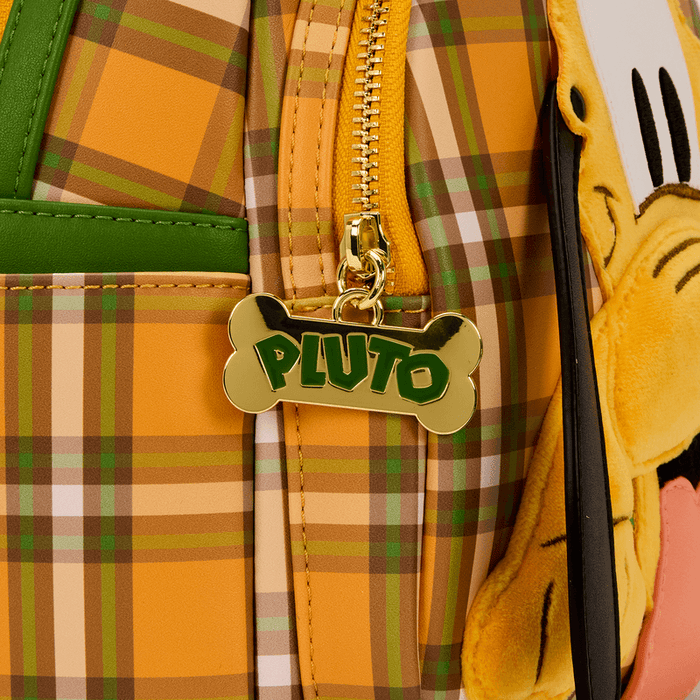 Close-up of Pluto bone-shaped gold zip pull on Loungefly plaid mini backpack