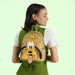 Model wearing the Loungefly Pluto plaid mini backpack against light green backdrop