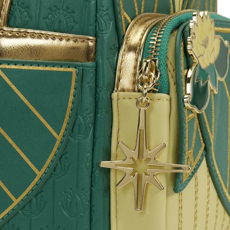 Close-up of the gold star charm and lotus applique on the Loungefly Disney The Princess and the Frog Tiana Cosplay Mini Backpack
