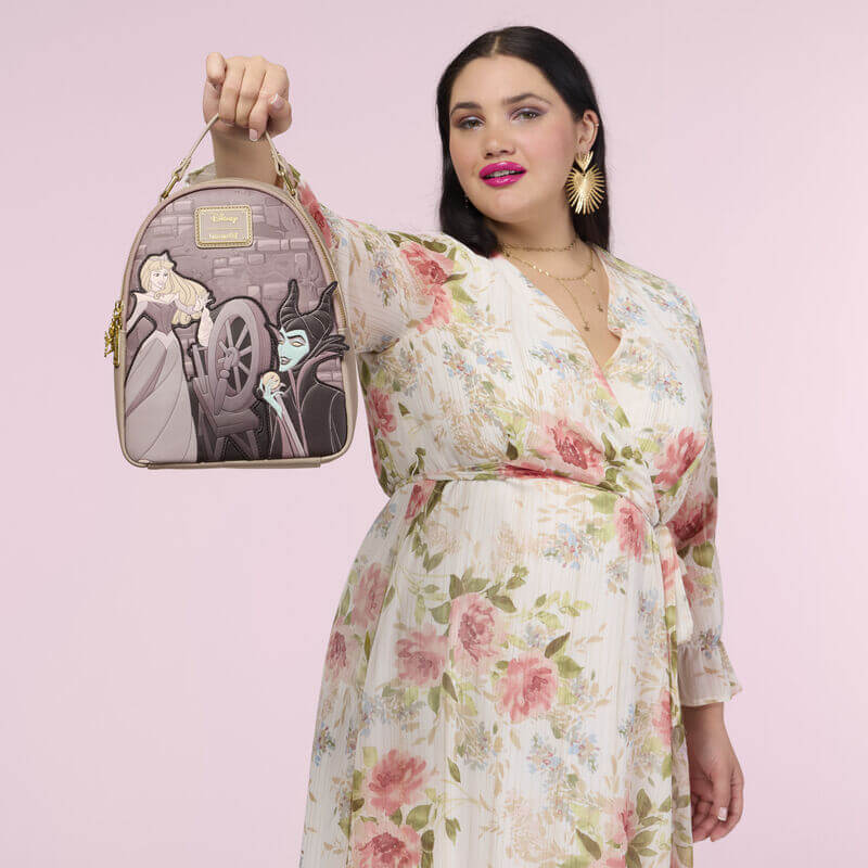 Lifestyle image of the Loungefly Disney Sleeping Beauty & Maleficent Spinning Wheel Mini Backpack held by a model
