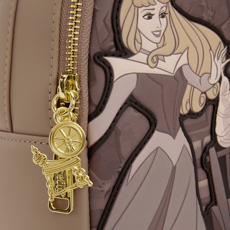 Close-up of the gold zipper charm on the Loungefly Disney Sleeping Beauty & Maleficent Spinning Wheel Mini Backpack featuring spinning wheel details