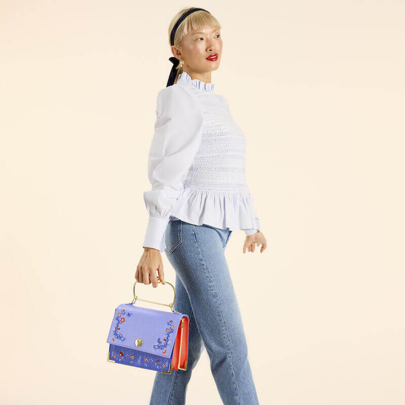 Model holding Loungefly Snow White crossbody by apple handle, full length