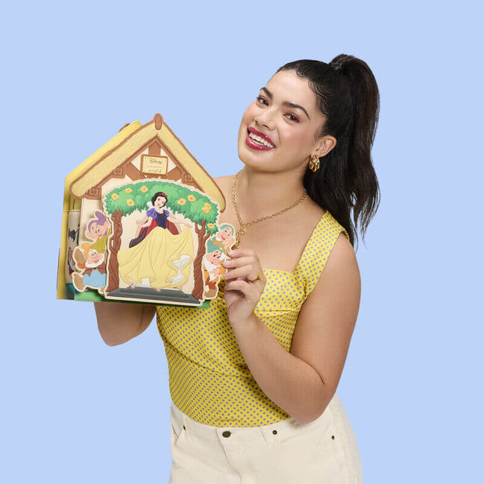 Model holding Loungefly Disney Snow White cottage mini backpack