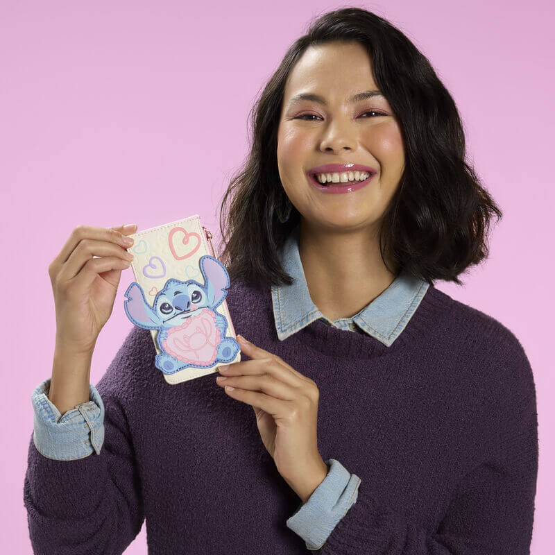 Model holding Loungefly Stitch and Angel Be Mine card holder in cream and pastel colours with Stitch heart applique