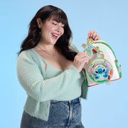 Model holding Loungefly Disney Stitch Christmas mini backpack with Scrump applique.