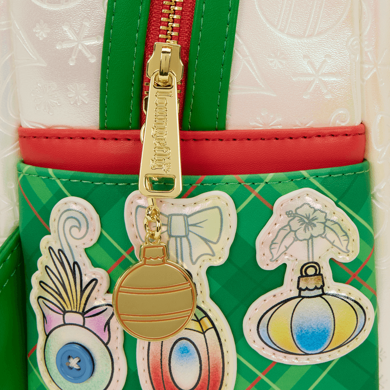 Close-up of gold bauble zip charm and ornament patches on green tartan side pocket.