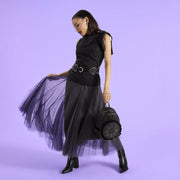 Model holding a black Loungefly Disney Villains mini backpack with ruffled front medallion