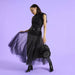 Model holding a black Loungefly Disney Villains mini backpack with ruffled front medallion