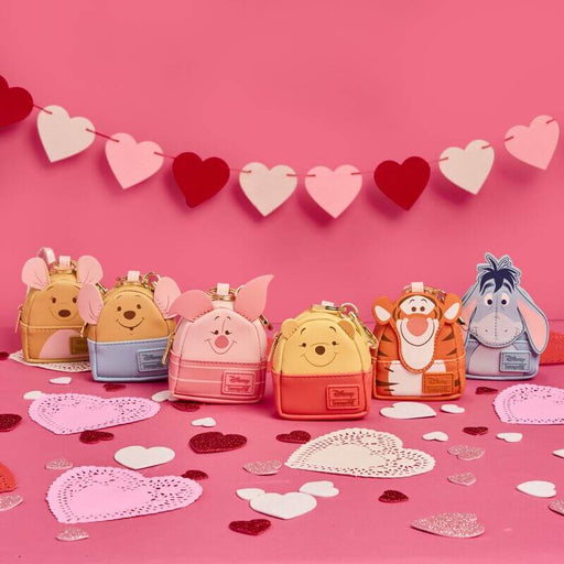 Loungefly Disney Winnie the Pooh mystery box mini backpack bag charms displayed together on a pink background with heart decorations