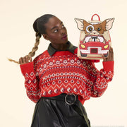 Lifestyle close-up of model holding the Loungefly Gizmo mini backpack with red patterned jumper.