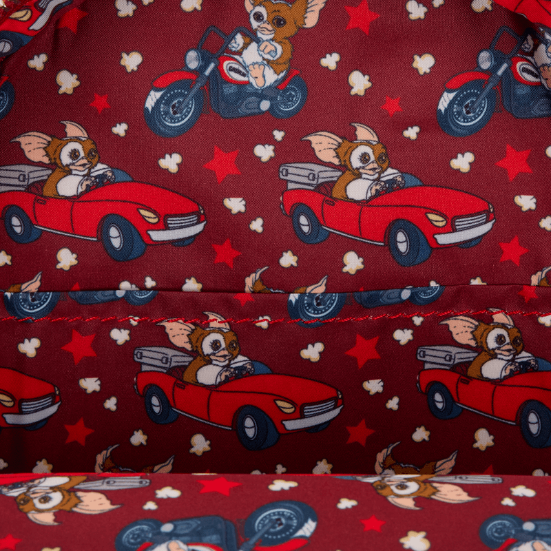 Interior lining of the Loungefly Gizmo backpack with Gizmo driving car and motorbike pattern on red.