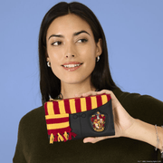 Model holding the Loungefly Harry Potter Gryffindor Winter Robes Wallet showing its compact size and knitted scarf design