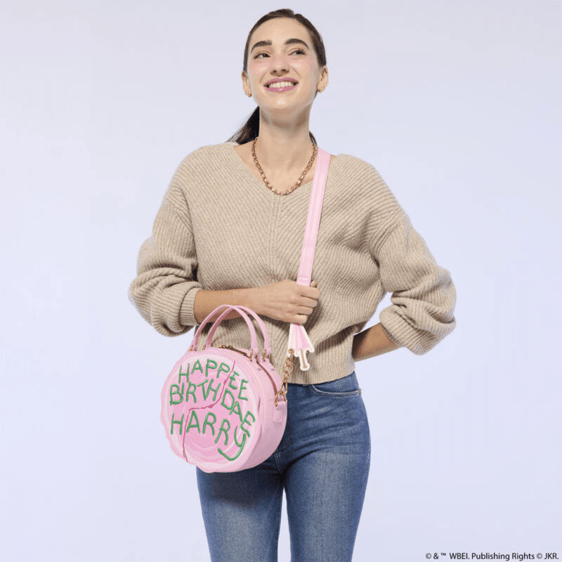 Model wearing Loungefly Harry Potter Birthday Cake Crossbody Bag with adjustable shoulder strap