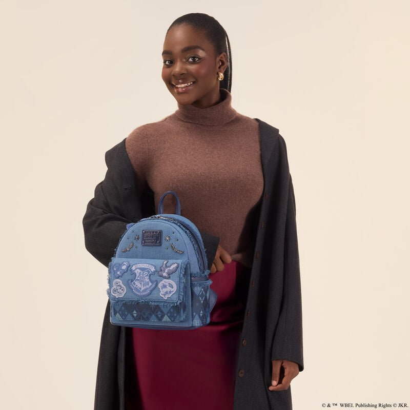 Model holding the Loungefly Harry Potter denim mini backpack, showing scale and Hogwarts crest.