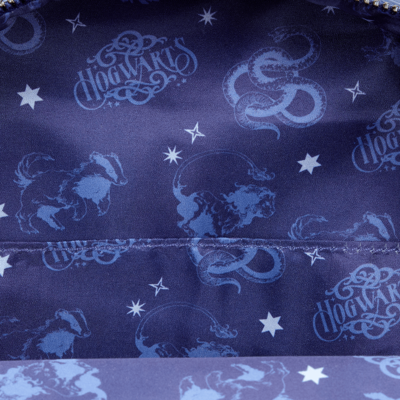 Close-up of navy Hogwarts print lining with house mascots and stars inside the Loungefly denim mini backpack.