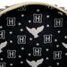Close-up detail of the Loungefly Harry Potter Hedwig Howler Cosplay Mini Backpack with white Hedwig silhouettes, stars and H icons on a black background