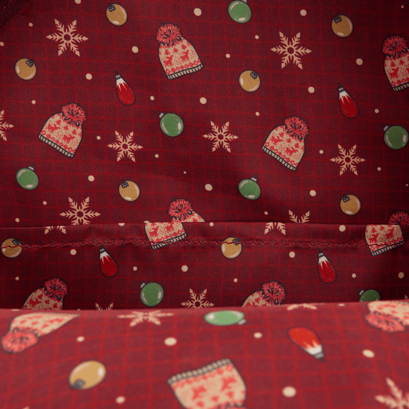 Printed lining of Loungefly Home Alone backpack with hats, baubles and snowflakes on red.