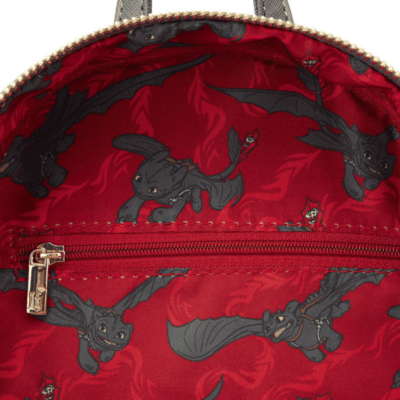 Inside lining of Loungefly Toothless mini backpack with red printed Toothless pattern and inner zip pocket