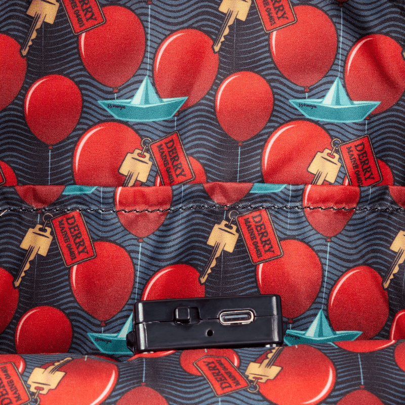 Interior lining with red balloons, Derry keys and paper boat inside the Loungefly IT Pennywise backpack.