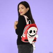 Model wearing the Loungefly Nightmare Before Christmas Jack Skellington Sandy Claws Mini Backpack with plush Santa hat and beard