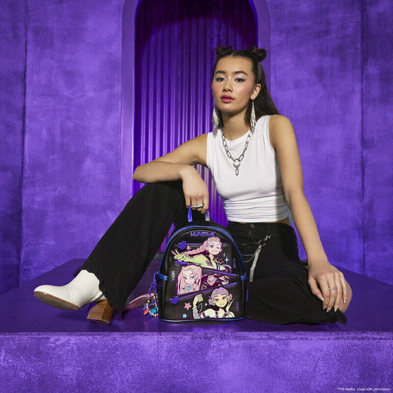 Model posing with the Loungefly K-Pop Demon Hunters Huntrix mini backpack against a purple backdrop