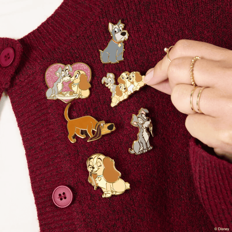 Disney Lady and the Tramp Loungefly enamel pins displayed on burgundy knitwear including the glitter spaghetti scene