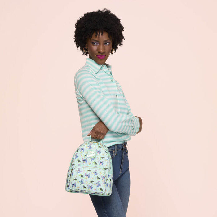 Lifestyle image of the Loungefly Disney Lilo & Stitch Animal Friends All-Over Print Mini Backpack being carried by a model
