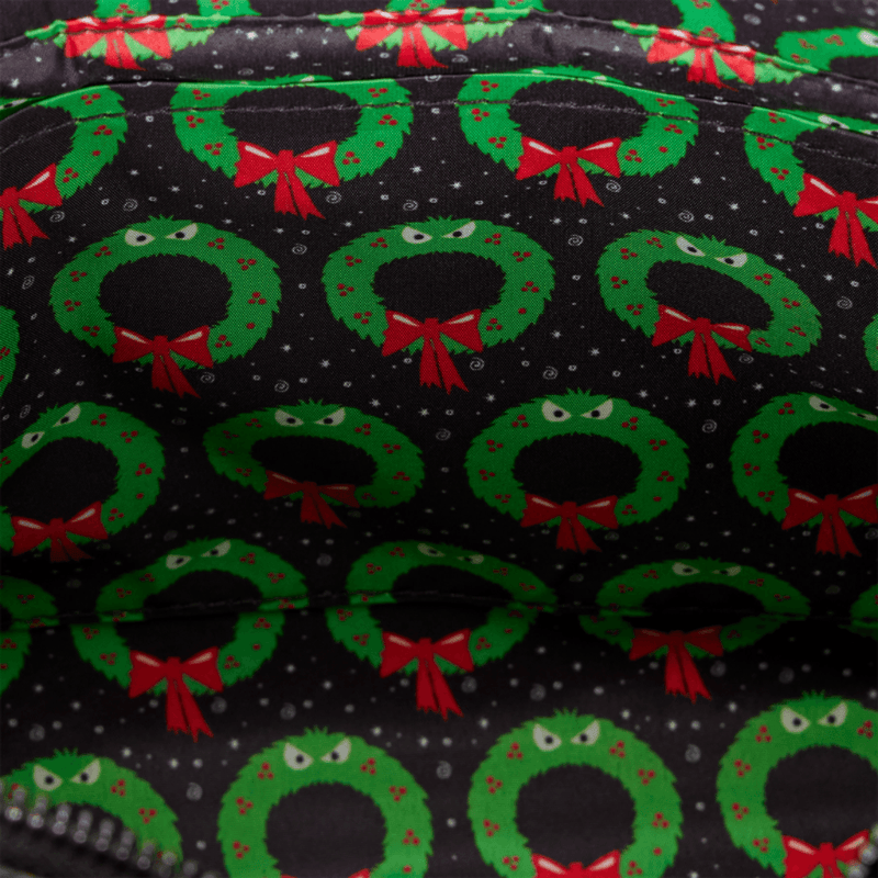 Interior lining of Loungefly Man-Eating Wreath Mini Tote with green monstrous wreaths, red bows and black patterned background