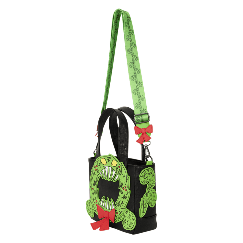 Side view of Loungefly Man-Eating Wreath Mini Tote showing dimensional green wreath appliqué, black handles and red bow detail