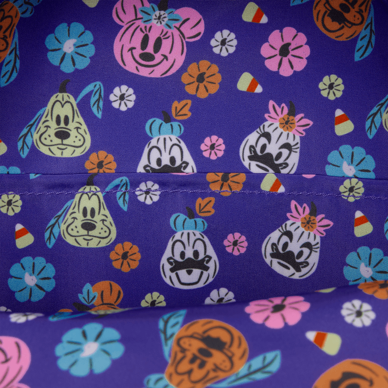 Close-up of purple lining with pumpkin-style Disney character faces and candy print inside the Loungefly backpack