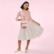 Model holding the Loungefly Disney Minnie Mouse floral mini backpack with Minnie ears and a pink velvet bow.
