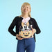 Model holding Loungefly Minnie Mouse Halloween mini backpack against a blue backdrop