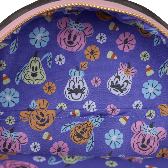 Close-up of purple lining with pumpkin-style Disney character faces and candy print inside the Loungefly Minnie Mouse backpack