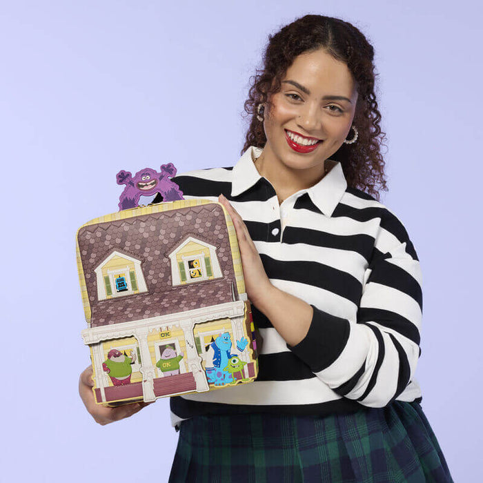 Model holding Loungefly Monsters University scare house mini backpack