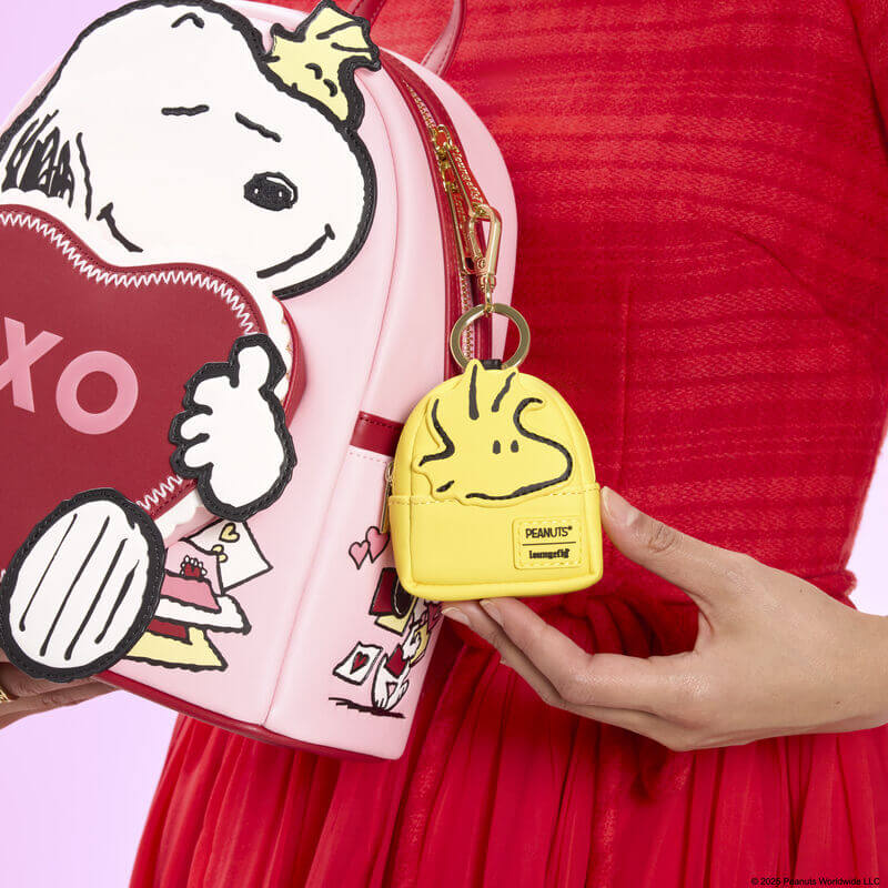 Woodstock mini backpack bag charm shown clipped to a bag in a lifestyle photo.