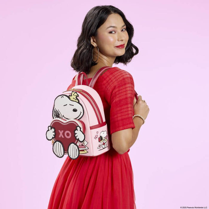 Model wearing Loungefly Peanuts Snoopy XO mini backpack in pink with 3D Snoopy and heart front pocket