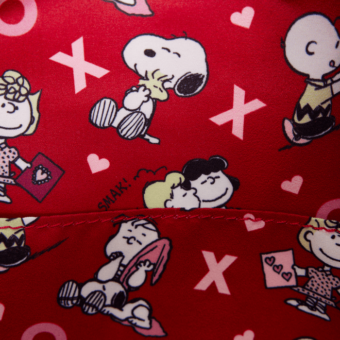 Close-up of red printed lining with Snoopy, hearts and XO pattern inside the Loungefly Peanuts mini backpack