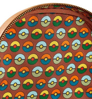 Inside lining of Loungefly Pokémon backpack with repeating Poké Ball pattern in retro colours