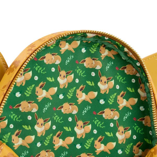 Close-up of green interior lining with playful Eevee illustrations inside the Loungefly mini backpack.