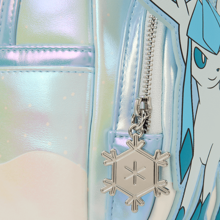 Close-up of the Loungefly Pokémon mini backpack snowflake zip charm on iridescent blue material.