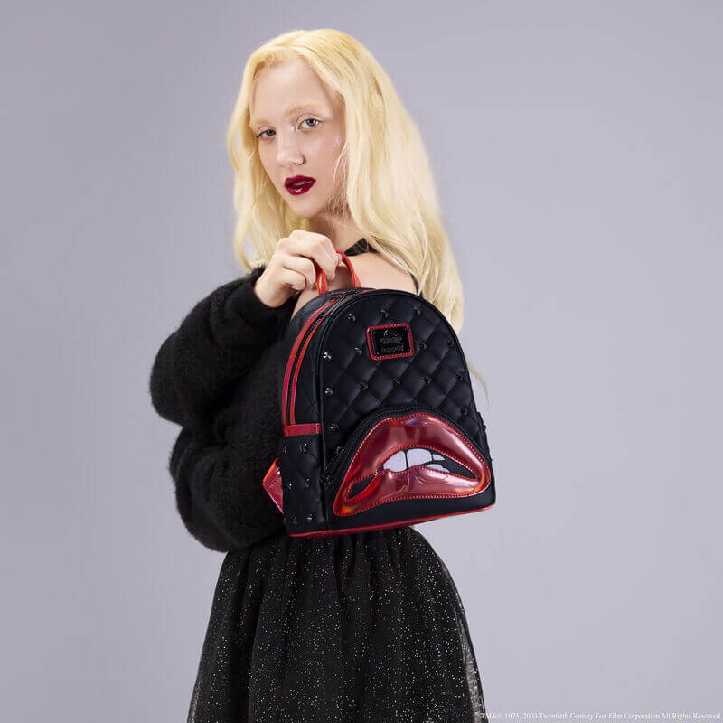 Model holding the Loungefly Rocky Horror Lips mini backpack against a grey backdrop, handheld lifestyle shot.