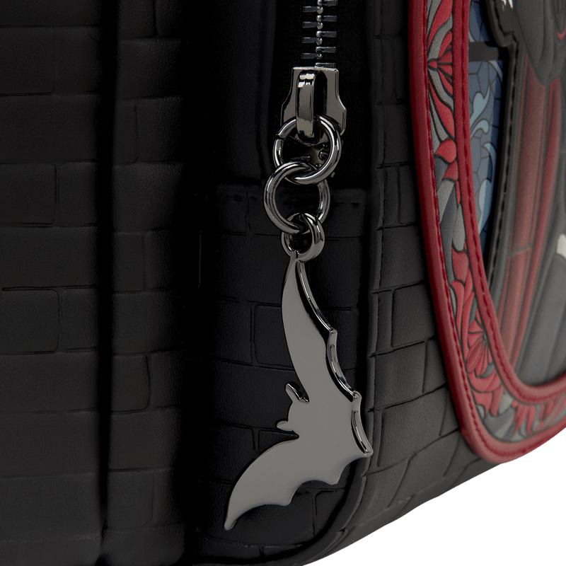 Close up of the Loungefly Universal Monsters Dracula mini backpack showing the molded metal bat zipper charm and black brick-effect texture
