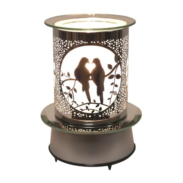 Lit view of rotating wax melt burner with dove design and heart-shaped pose

