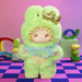 Matcha Grape plush – mint‑green frog suit with golden crown and frilly collar.

