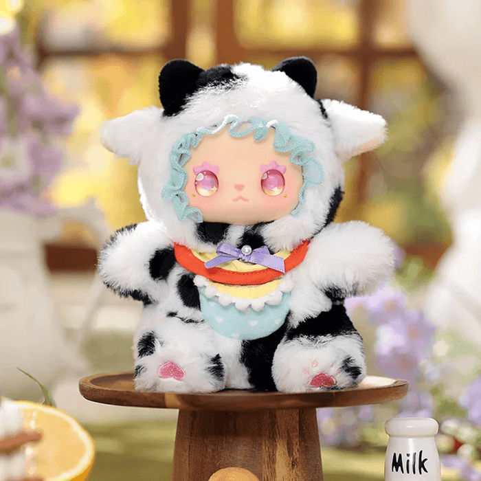 Tonton Cow plush mini in black-and-white cow suit with pastel neck ribbon
