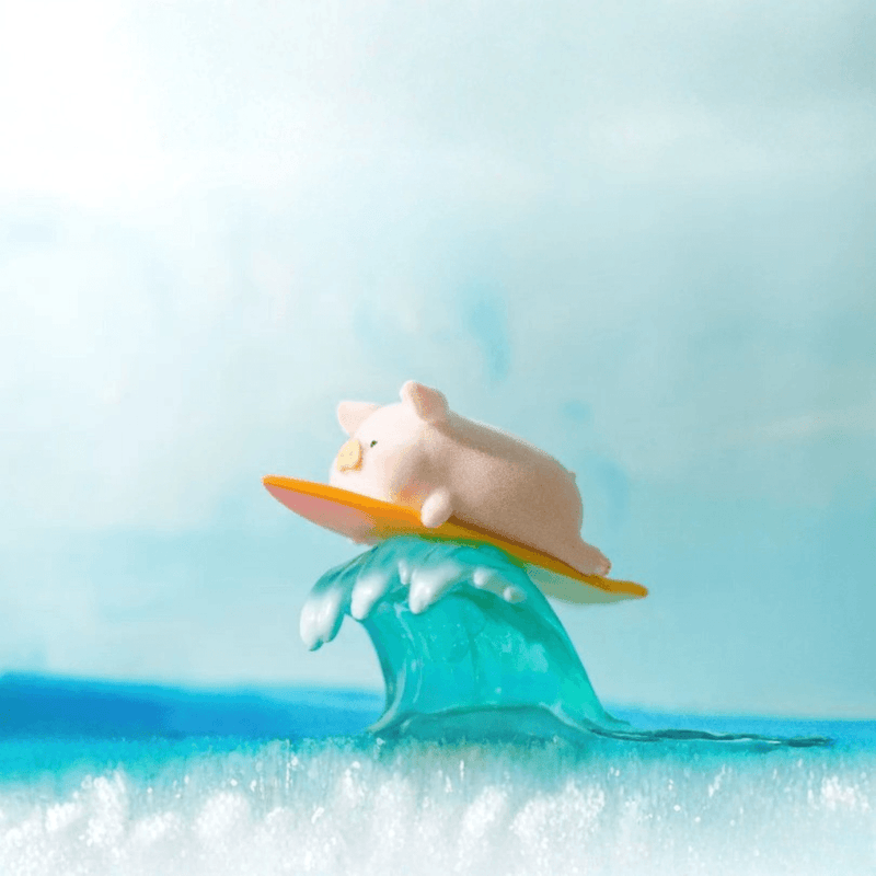 LuLu the Piggy Beach Party Blind Box Series Surf figure lying on a surfboard riding a blue wave
