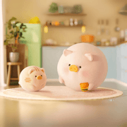 Lulu the Piggy Home Life blind box “Burger Buddy” figure—round pig holding a mini burger while cat companion watches in the kitchen.
