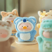 Centre-focus Lulu the Piggy Downshifting Koala blind box keyring in blue koala costume, friends softly blurred behind.
