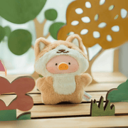 Lulu the Piggy Friendly Fox blind box keyring, tan fox hood and forest-floor cut-outs creating playful nature stage.
