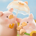 LuLu the Piggy's Travel Series Blind Box display with pig figures sharing an umbrella and holding a cat companion